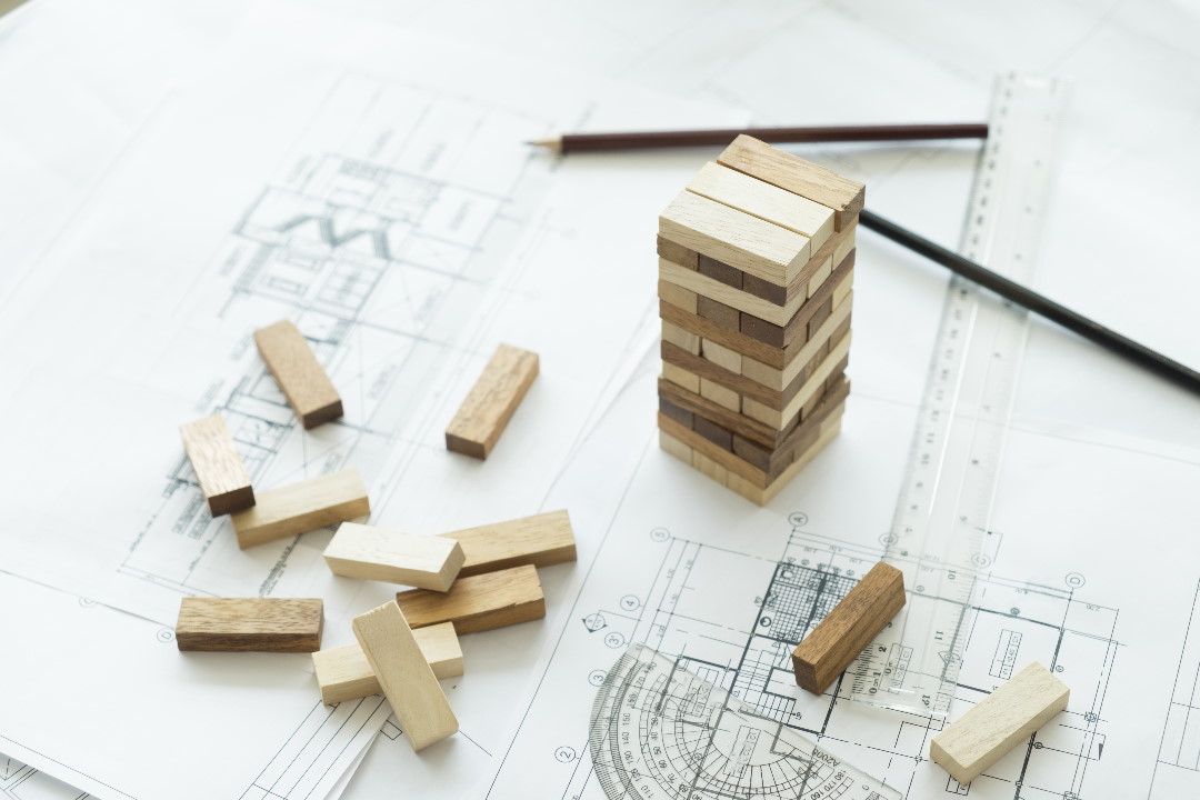 Planning, risk and strategy of project management in business, businessman and engineer gambling placing wooden block on a tower.Business and construction concept.